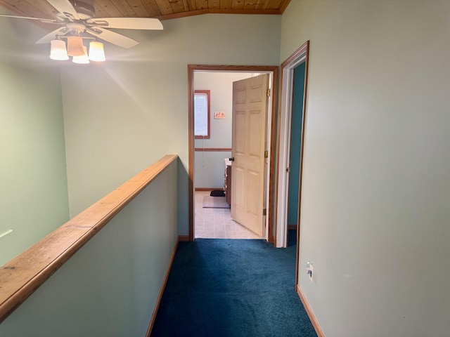 hall featuring baseboards, an upstairs landing, wooden ceiling, and carpet