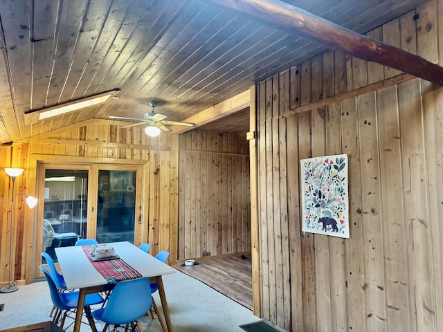 dining room featuring wood walls, ceiling fan, wood ceiling, carpet flooring, and vaulted ceiling