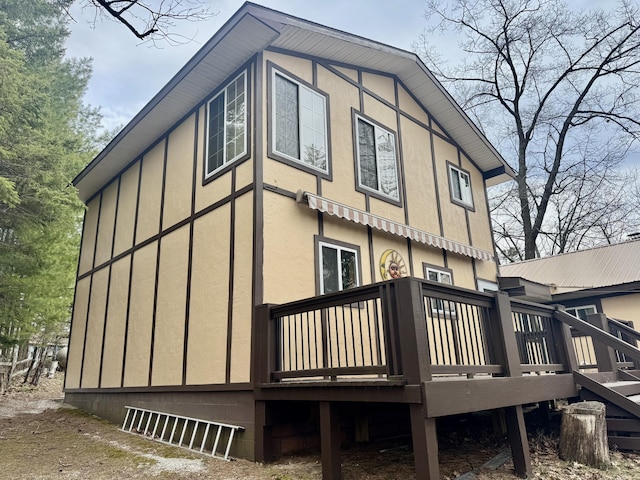 view of property exterior featuring stucco siding and a wooden deck