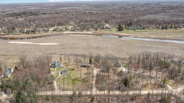 birds eye view of property with a view of trees and a water view