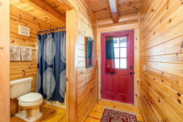 entryway featuring wood walls, wood ceiling, hardwood / wood-style floors, and beamed ceiling