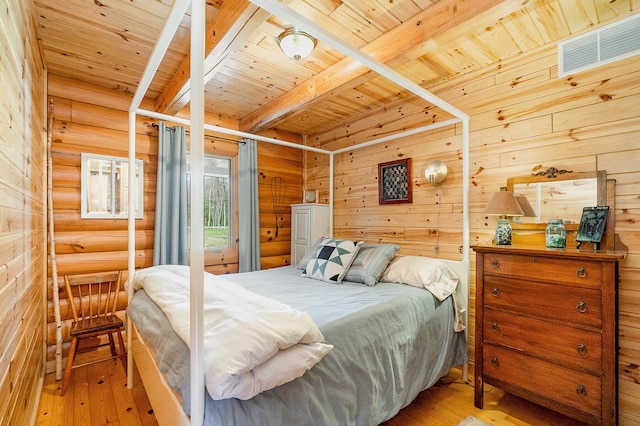 bedroom featuring beam ceiling, visible vents, log walls, and wood ceiling