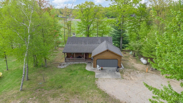 3525 E Pointe Dr, Beaverton, MI 48612 - log-style house with covered porch, log siding, driveway, and a garage