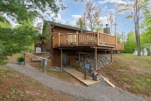 3525 E Pointe Dr, Beaverton, MI 48612 - rear view of house with a deck, log siding, a chimney, and central AC unit