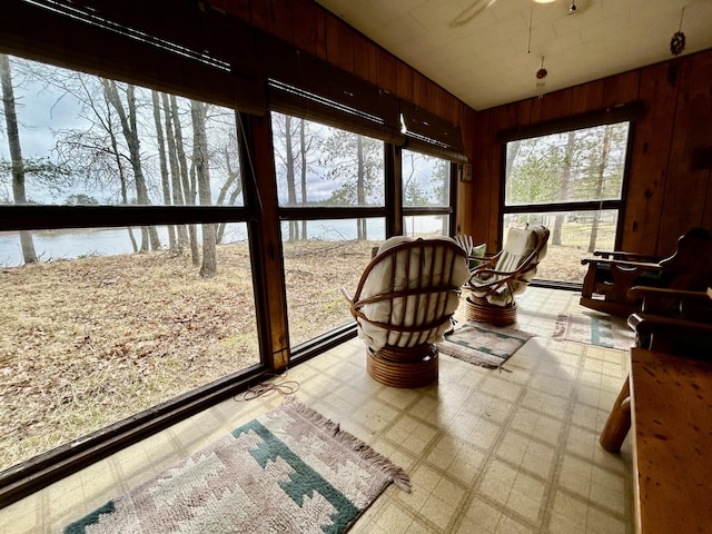 sunroom featuring tile patterned floors and wood walls