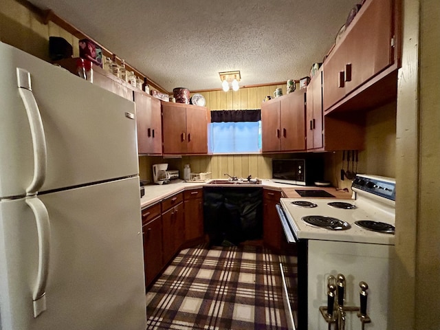 kitchen with a sink, light countertops, black appliances, and a textured ceiling
