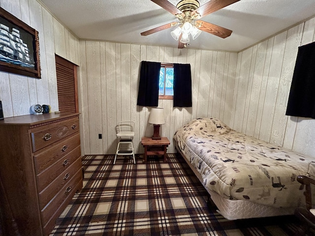 bedroom with a textured ceiling and wood walls