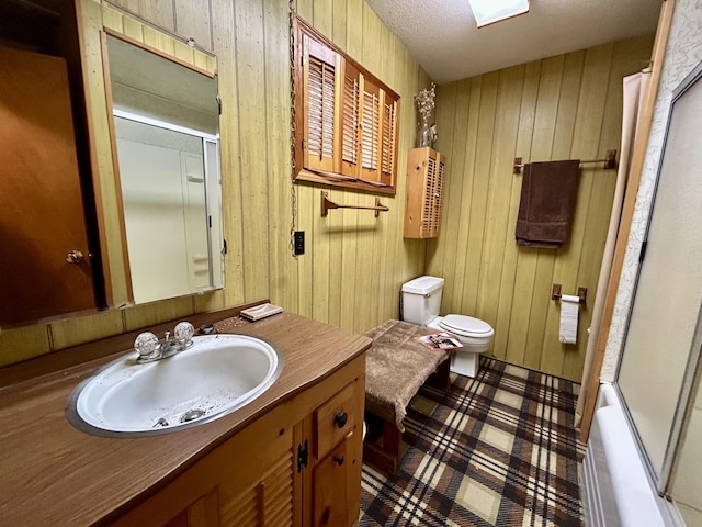 full bath with wooden walls, toilet, tile patterned floors, and vanity