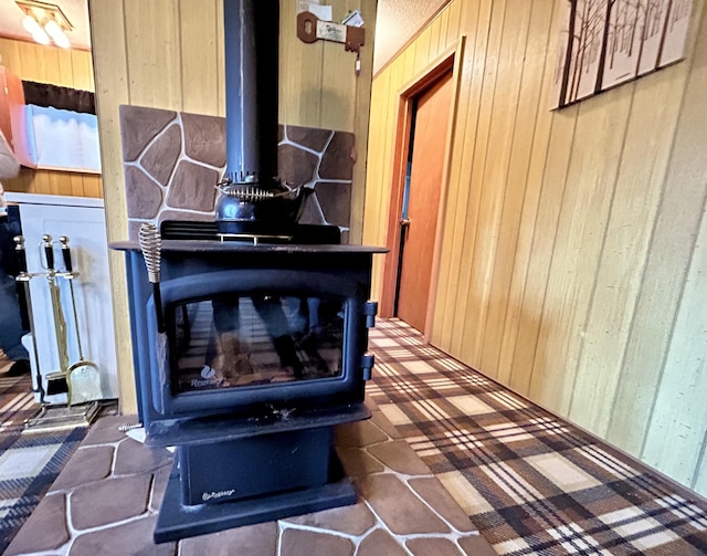 interior details with wooden walls and a wood stove
