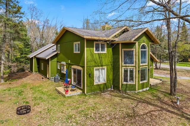 1406 Opal Lake Rd, Gaylord, MI 49735 - back of property featuring a chimney, central AC, and roof with shingles