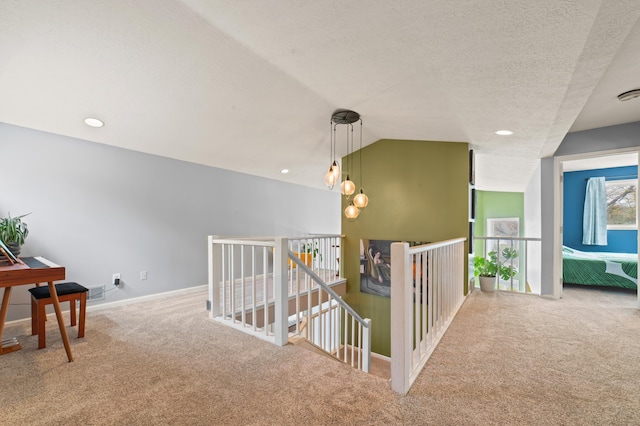 1406 Opal Lake Rd, Gaylord, MI 49735 - hall featuring carpet floors, an upstairs landing, baseboards, lofted ceiling, and a textured ceiling
