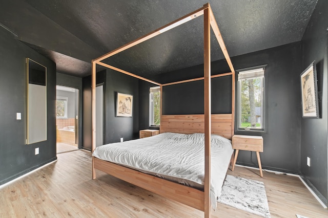 1406 Opal Lake Rd, Gaylord, MI 49735 - bedroom with wood finished floors, baseboards, and connected bathroom