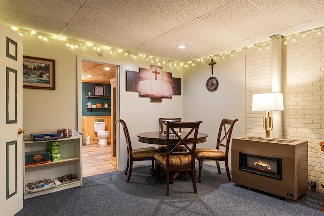 6075 W Edgar St, Pellston, MI 49769 - carpeted dining room featuring a paneled ceiling and brick wall