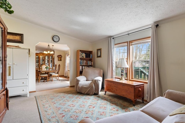 6075 W Edgar St, Pellston, MI 49769 - sitting room with a textured ceiling, crown molding, a chandelier, arched walkways, and vaulted ceiling