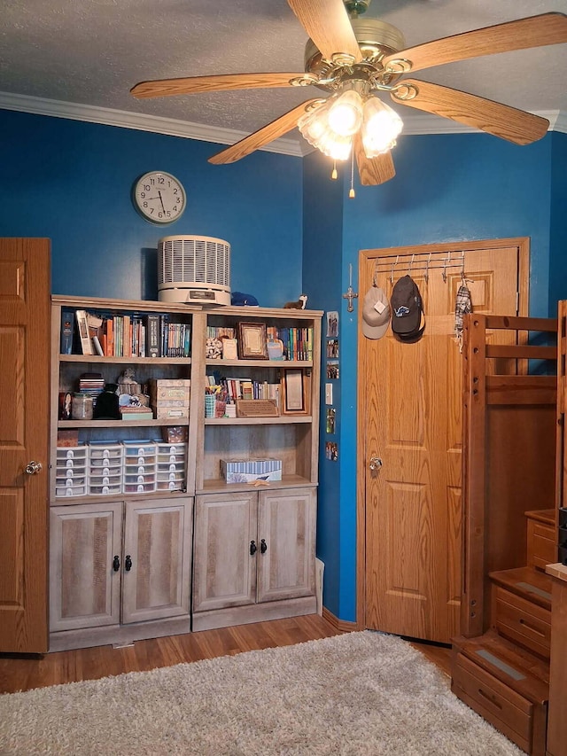 6075 W Edgar St, Pellston, MI 49769 - bedroom featuring crown molding, wood finished floors, ceiling fan, and a textured ceiling