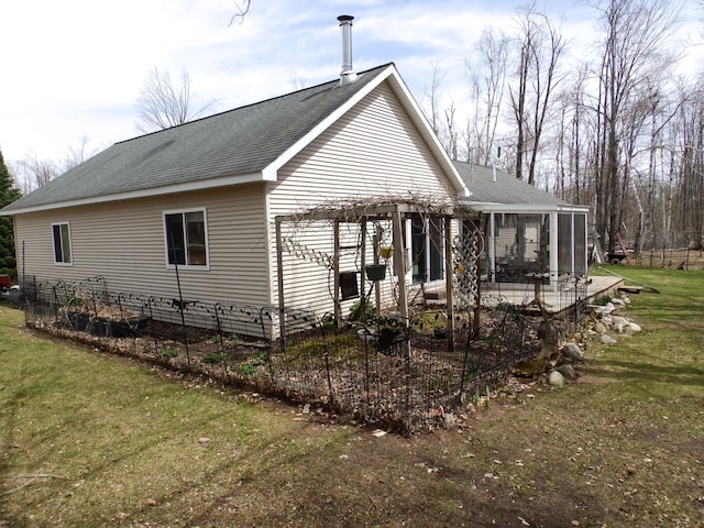 view of home's exterior featuring roof with shingles, a patio, a pergola, a lawn, and a sunroom
