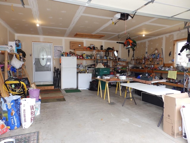 garage featuring freestanding refrigerator, a workshop area, and a garage door opener