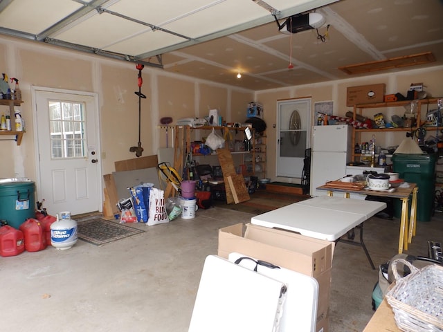 garage with freestanding refrigerator and a garage door opener