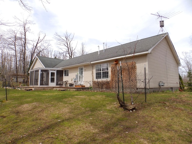 rear view of property with a sunroom, a shingled roof, and a yard