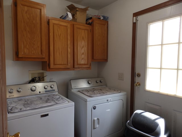 clothes washing area featuring cabinet space and independent washer and dryer