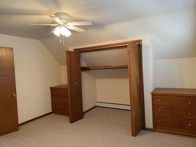 unfurnished bedroom featuring ceiling fan, light colored carpet, vaulted ceiling, a baseboard radiator, and a closet