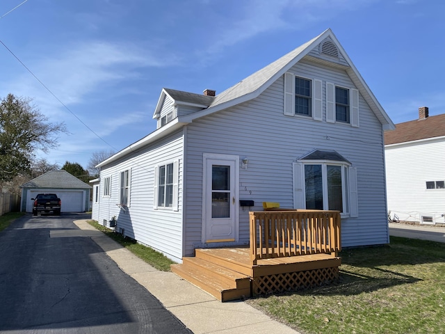 exterior space featuring an outbuilding, a deck, and a detached garage