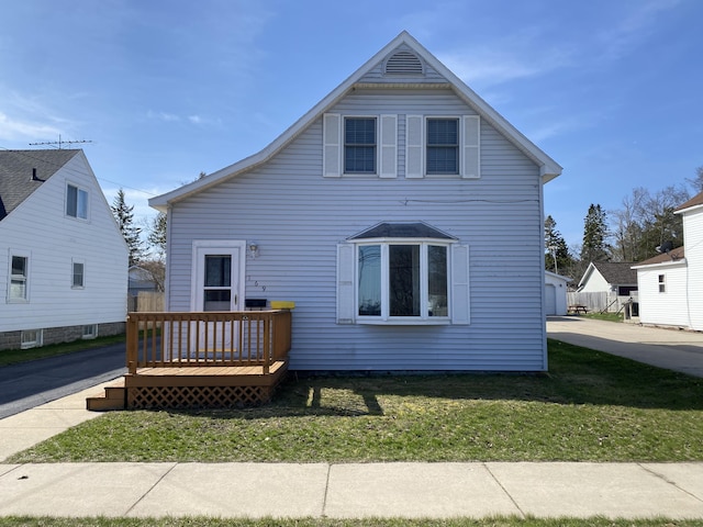 back of house featuring a wooden deck and a yard