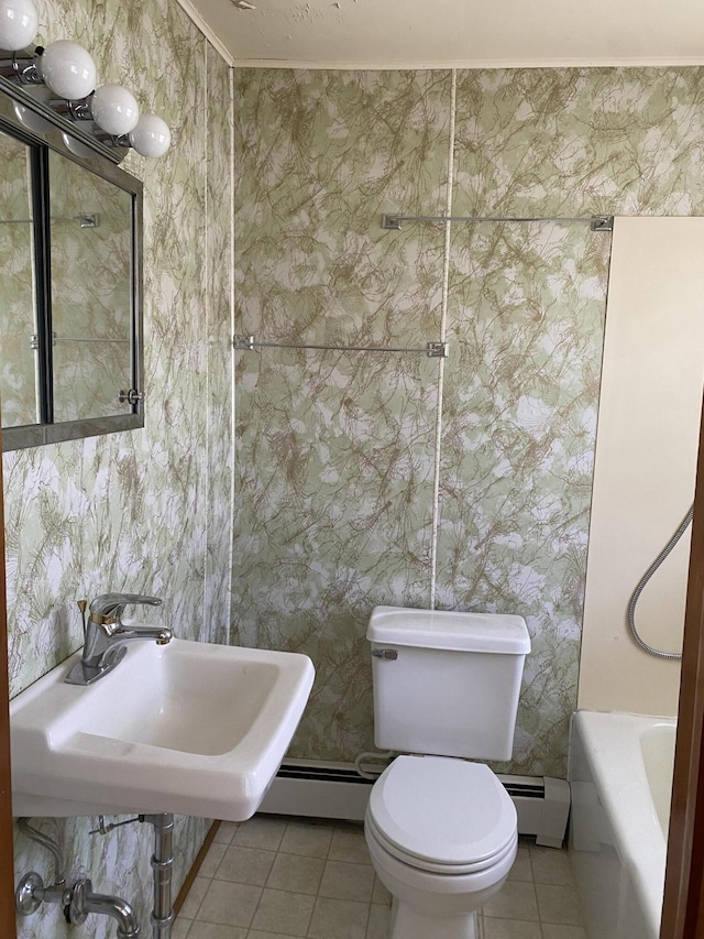 bathroom with tile patterned flooring, toilet, a bathtub, baseboard heating, and a sink
