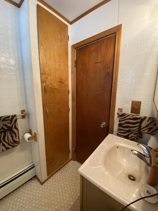 bathroom with vanity, tile patterned floors, ornamental molding, and a baseboard radiator