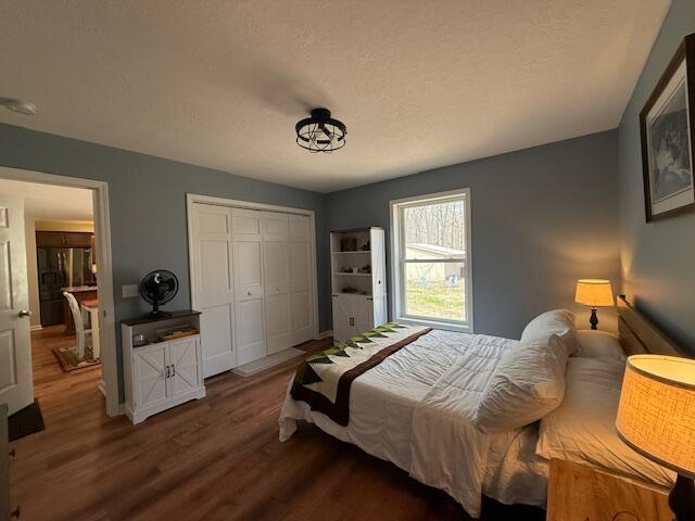 bedroom featuring a closet, baseboards, and wood finished floors