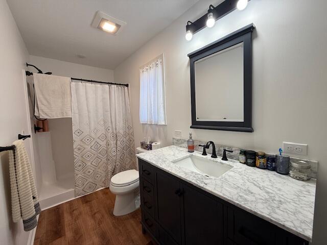 full bath with vanity, toilet, wood finished floors, and a shower with shower curtain