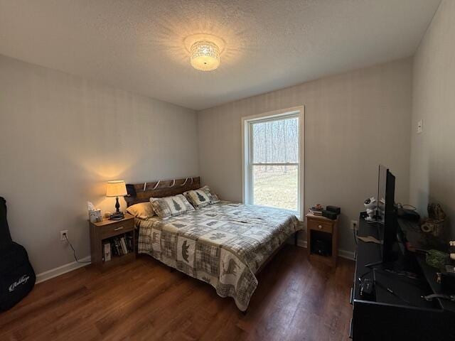 bedroom with baseboards and dark wood-style floors