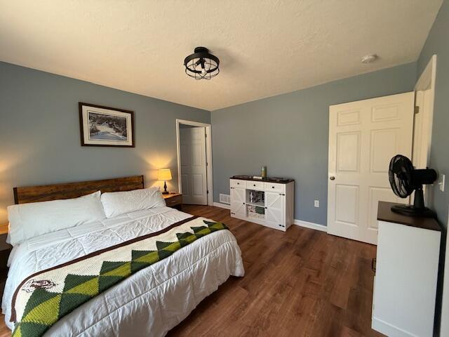 bedroom with baseboards and wood finished floors