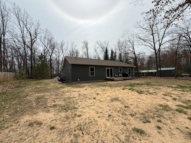back of property featuring fence and a wooden deck