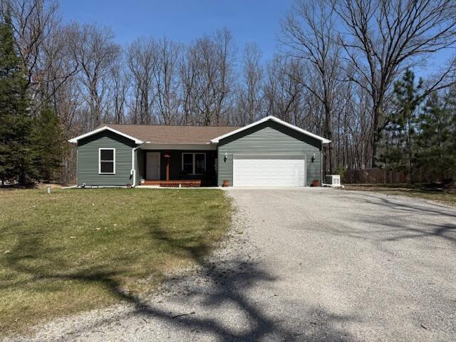 ranch-style home with fence, a front lawn, a garage, a porch, and driveway