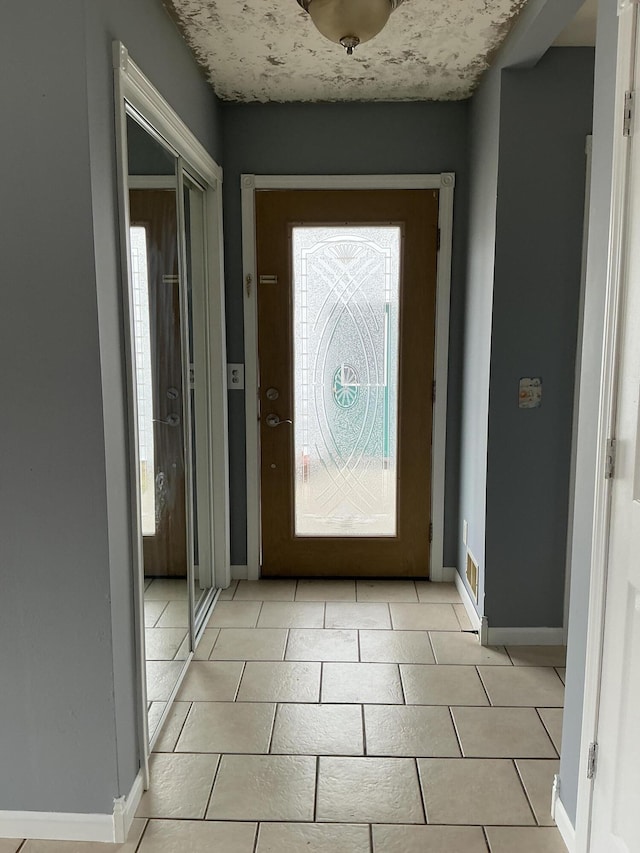 120 Marina St, Houghton Lake, MI 48629 - doorway with light tile patterned floors and baseboards