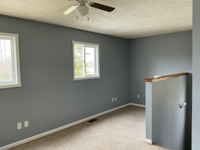 120 Marina St, Houghton Lake, MI 48629 - empty room featuring visible vents, carpet floors, baseboards, a textured ceiling, and a ceiling fan