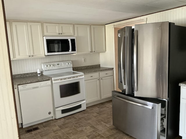 120 Marina St, Houghton Lake, MI 48629 - kitchen featuring stainless steel appliances, brick patterned floor, white cabinetry, and visible vents