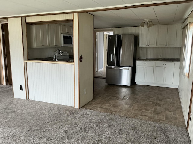 120 Marina St, Houghton Lake, MI 48629 - kitchen with stainless steel appliances, dark countertops, white cabinetry, and a sink