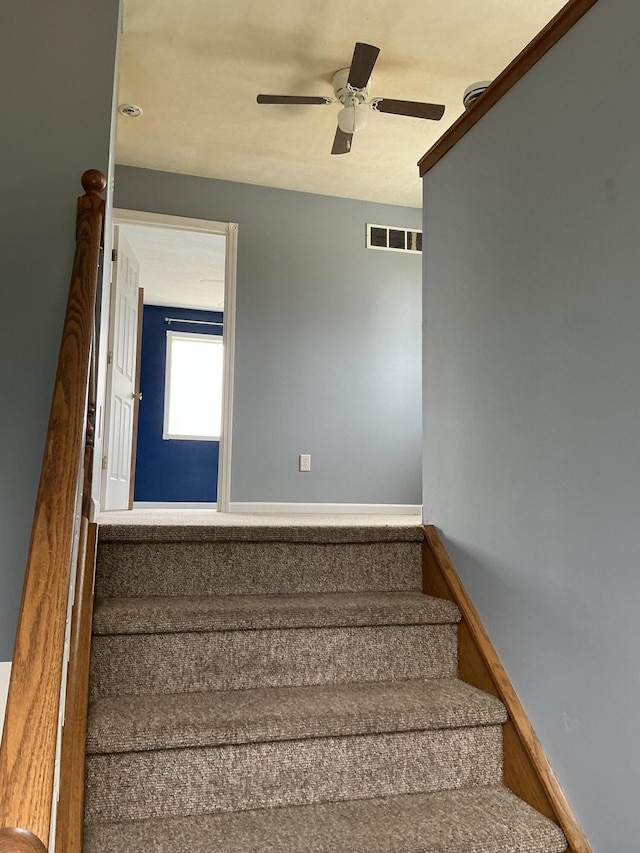 120 Marina St, Houghton Lake, MI 48629 - stairway featuring ceiling fan, visible vents, and baseboards