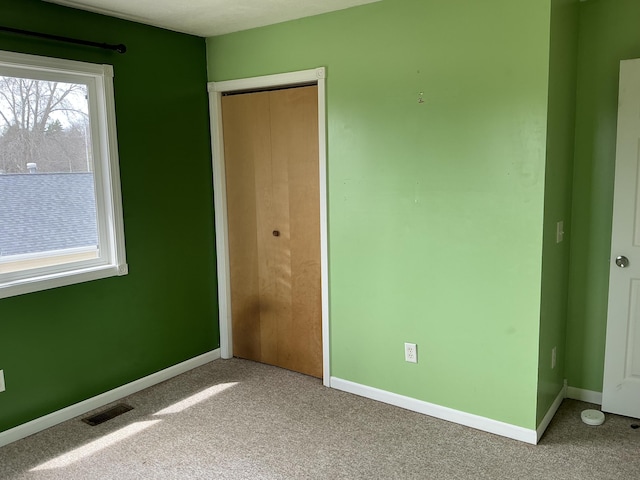 120 Marina St, Houghton Lake, MI 48629 - unfurnished bedroom featuring visible vents, carpet, baseboards, and a closet