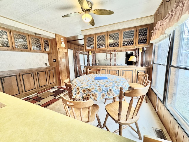 427 Goline Rd, Grayling, MI 49738 - dining room with a ceiling fan, wood walls, and visible vents