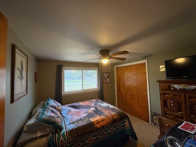 carpeted bedroom with a ceiling fan and a closet