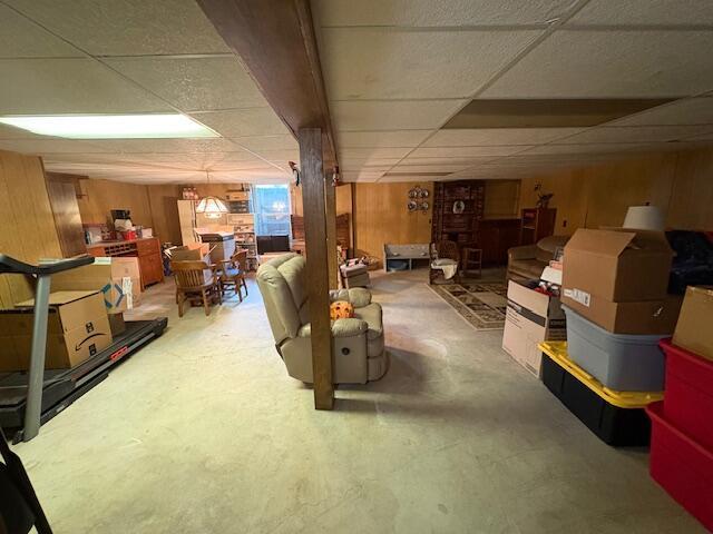 finished below grade area featuring wooden walls and a paneled ceiling