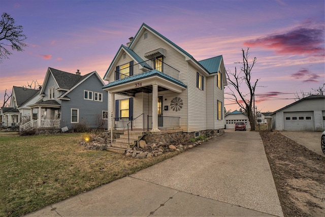 334 E Main St, Gaylord, MI 49735 - view of front of property featuring a balcony, covered porch, metal roof, a detached garage, and an outdoor structure