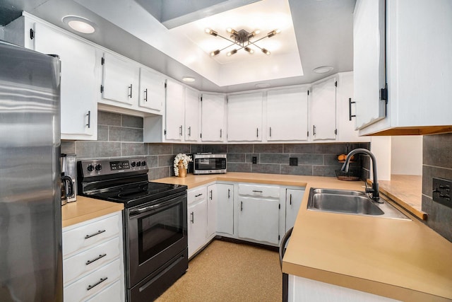 334 E Main St, Gaylord, MI 49735 - kitchen with stainless steel appliances, a sink, backsplash, light countertops, and white cabinetry