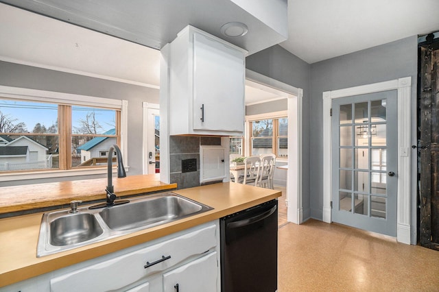 334 E Main St, Gaylord, MI 49735 - kitchen featuring black dishwasher, a sink, light countertops, white cabinetry, and plenty of natural light