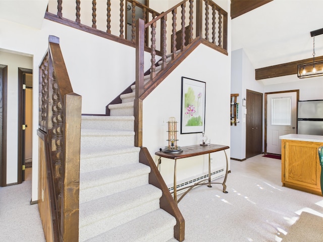 stairway with baseboards, carpet flooring, and a baseboard heating unit