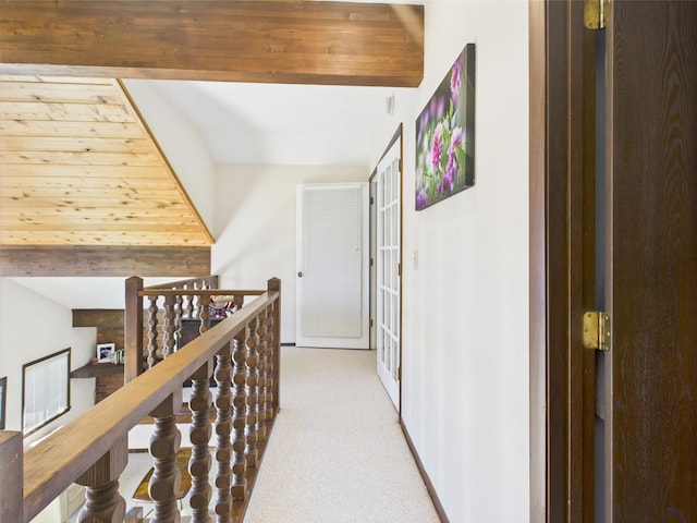 hallway featuring baseboards, an upstairs landing, and light colored carpet
