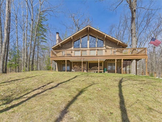 back of property with a lawn, a chimney, and a deck